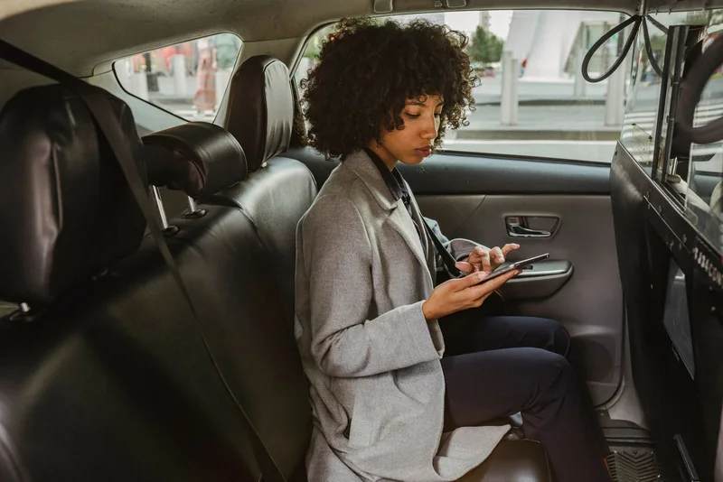 Customer entering an online request on a smartphone while seated in a parked car